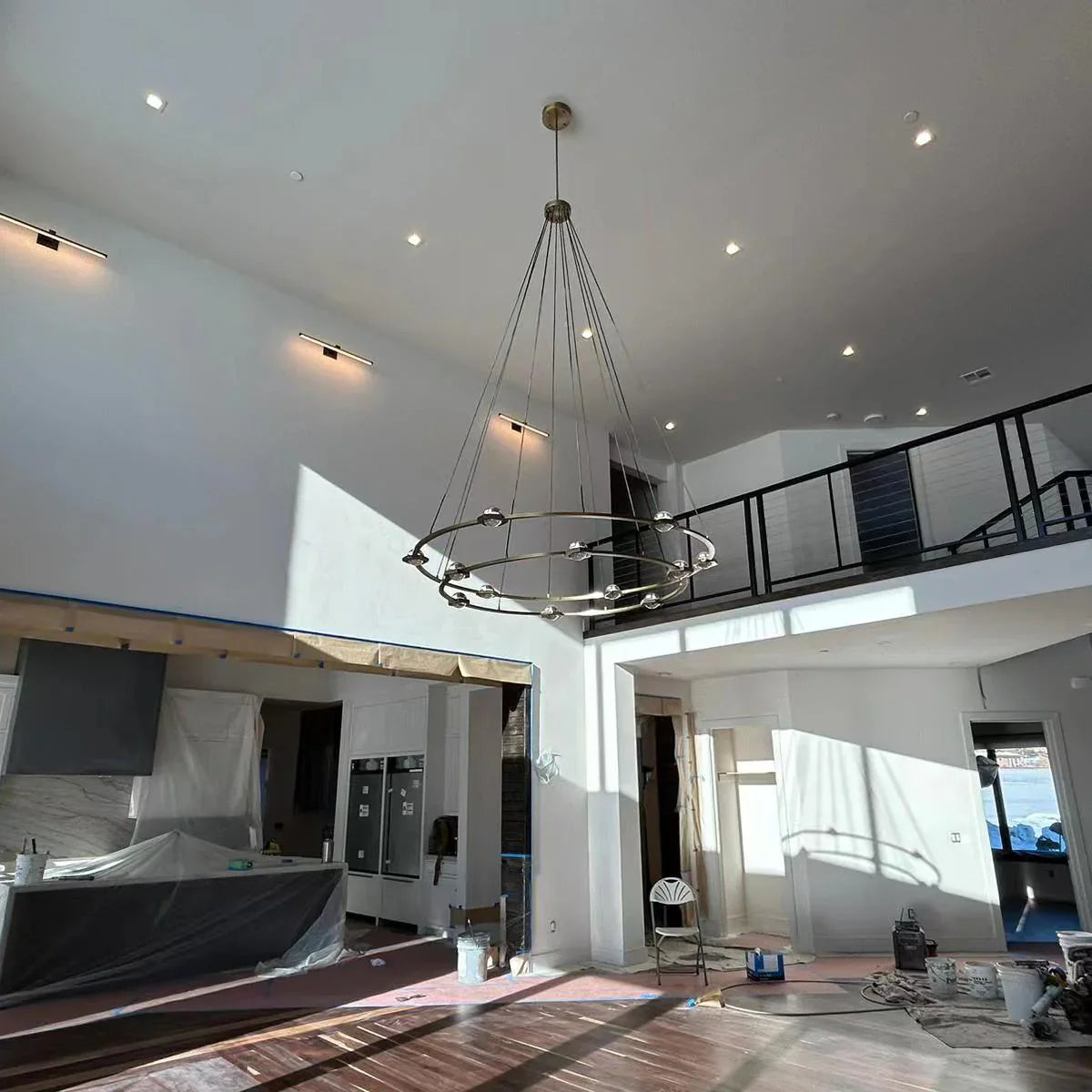 Modern living room with a chandelier, large windows, and minimal decor.